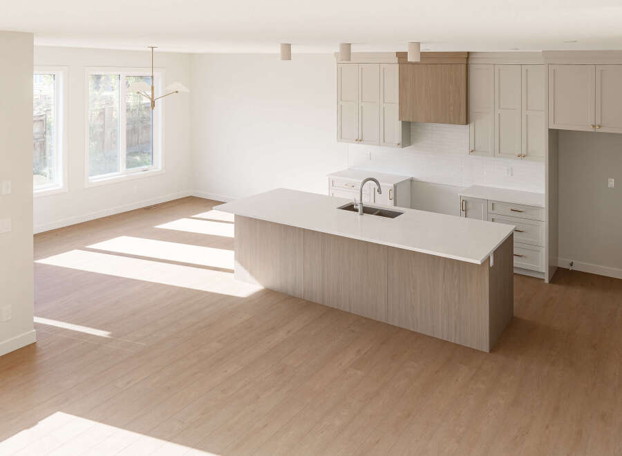Experience modern living in this spacious open-concept kitchen and living area, bathed in natural light from large windows.