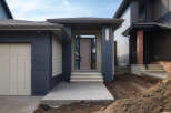 Discover modern living in this stunning new construction home, featuring a striking facade with dark blue brick and complementary siding.
