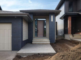Discover modern living in this stunning new construction home, featuring a striking facade with dark blue brick and complementary siding.