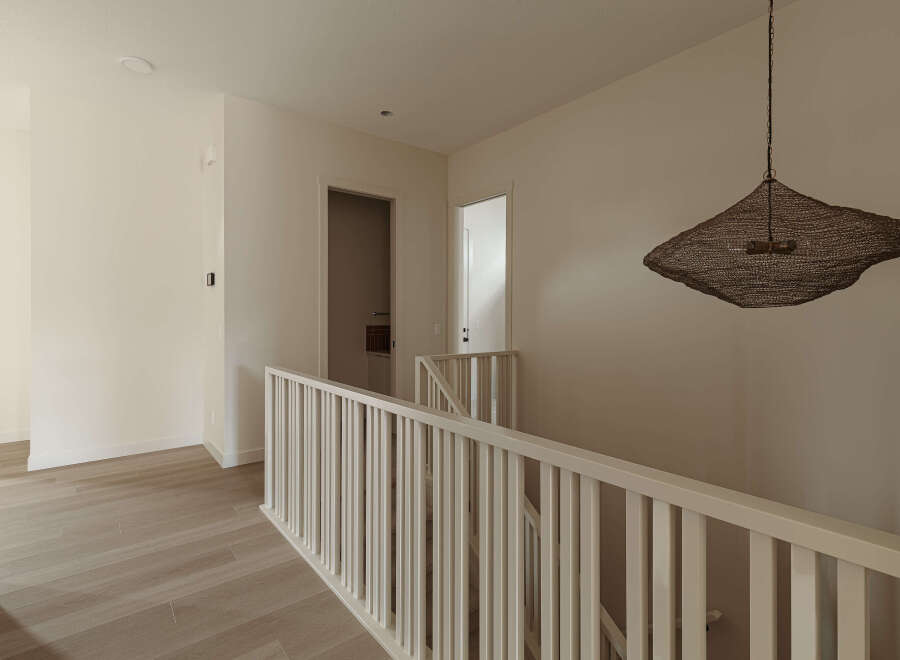 This modern hallway features light wood flooring and neutral-toned walls, creating a bright and airy atmosphere.