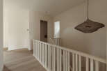 This modern hallway features light wood flooring and neutral-toned walls, creating a bright and airy atmosphere.