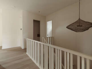 This modern hallway features light wood flooring and neutral-toned walls, creating a bright and airy atmosphere.