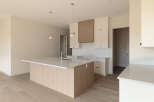 Discover this modern kitchen featuring a spacious island with a waterfall countertop and a sleek faucet.
