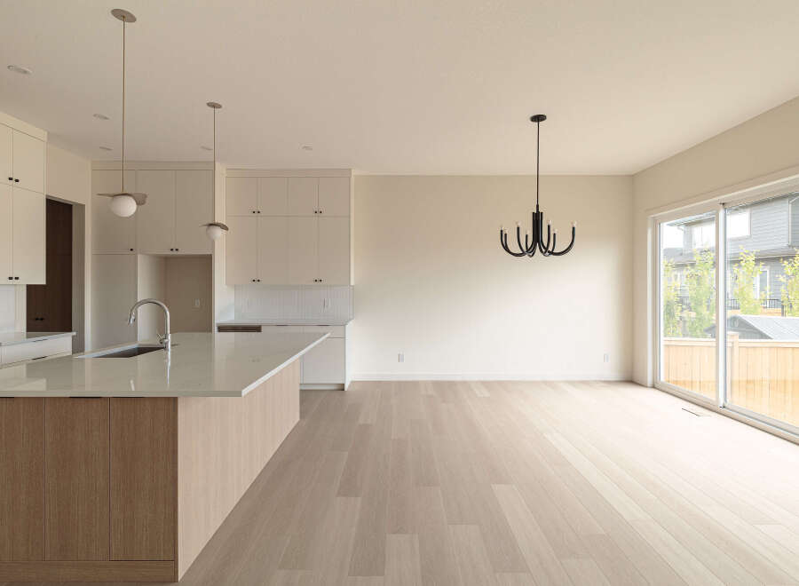 Experience modern living in this spacious open-concept home, featuring a sleek kitchen with a large island and ample cabinet space.