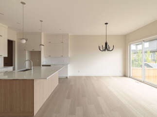 Experience modern living in this spacious open-concept home, featuring a sleek kitchen with a large island and ample cabinet space.
