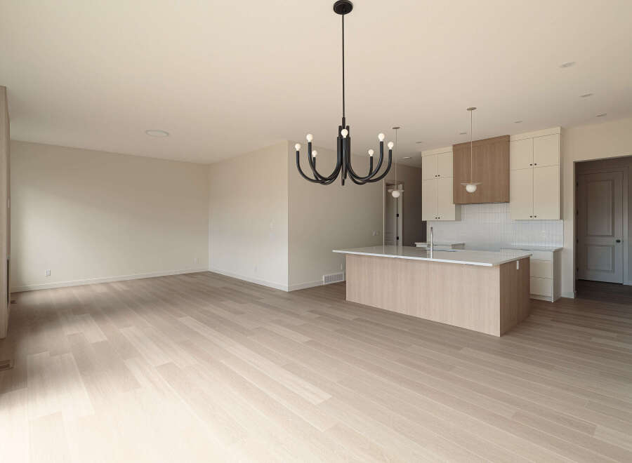 Experience modern living in this spacious open-concept home, featuring a sleek kitchen island and elegant cabinetry.