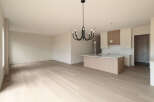Experience modern living in this spacious open-concept home, featuring a sleek kitchen island and elegant cabinetry.