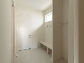 Step into this inviting entryway, featuring a sleek white door with modern black hardware, leading into a bright and airy space.
