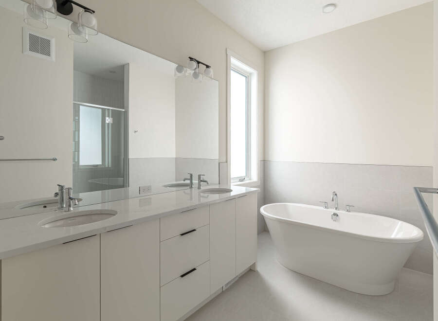 Experience luxury in this modern bathroom, featuring a sleek double vanity with quartz countertops and undermount sinks.