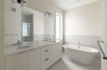 Experience luxury in this modern bathroom, featuring a sleek double vanity with quartz countertops and undermount sinks.