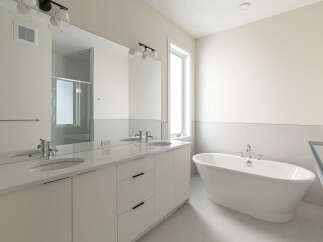 Experience luxury in this modern bathroom, featuring a sleek double vanity with quartz countertops and undermount sinks.