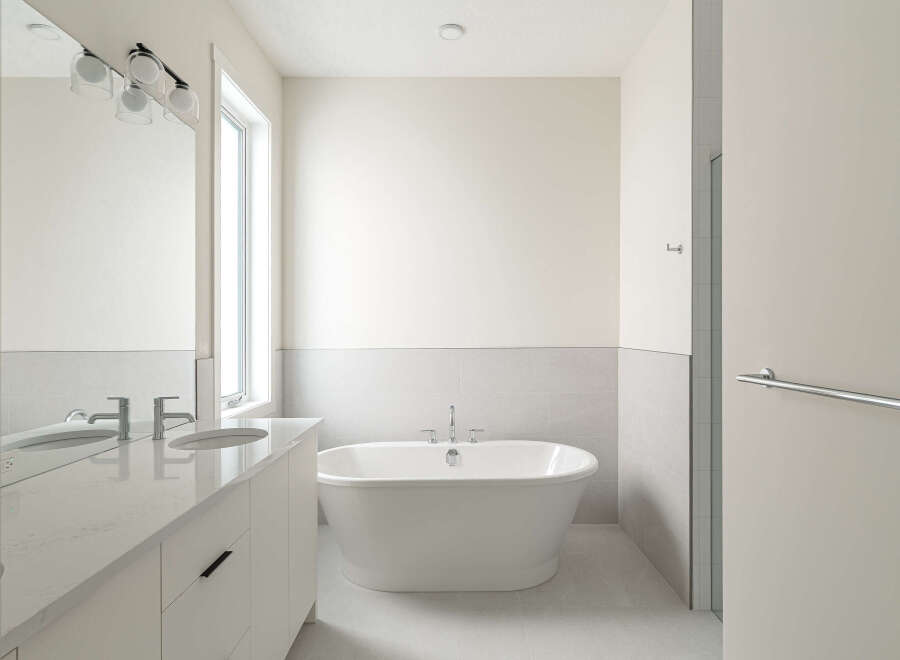 Experience modern luxury in this stunning bathroom, featuring a sleek double vanity with quartz countertops and contemporary chrome faucets.