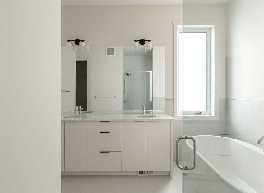 Experience luxury in this modern bathroom featuring a spacious double vanity with sleek cabinetry and ample counter space.