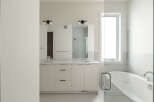 Experience luxury in this modern bathroom featuring a spacious double vanity with sleek cabinetry and ample counter space.