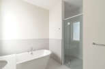 Experience modern luxury in this stunning bathroom, featuring a freestanding soaking tub and a sleek glass-enclosed shower.