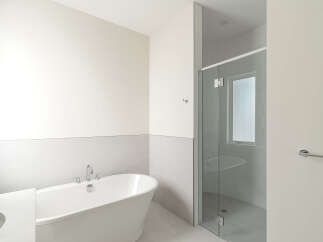 Experience modern luxury in this stunning bathroom, featuring a freestanding soaking tub and a sleek glass-enclosed shower.