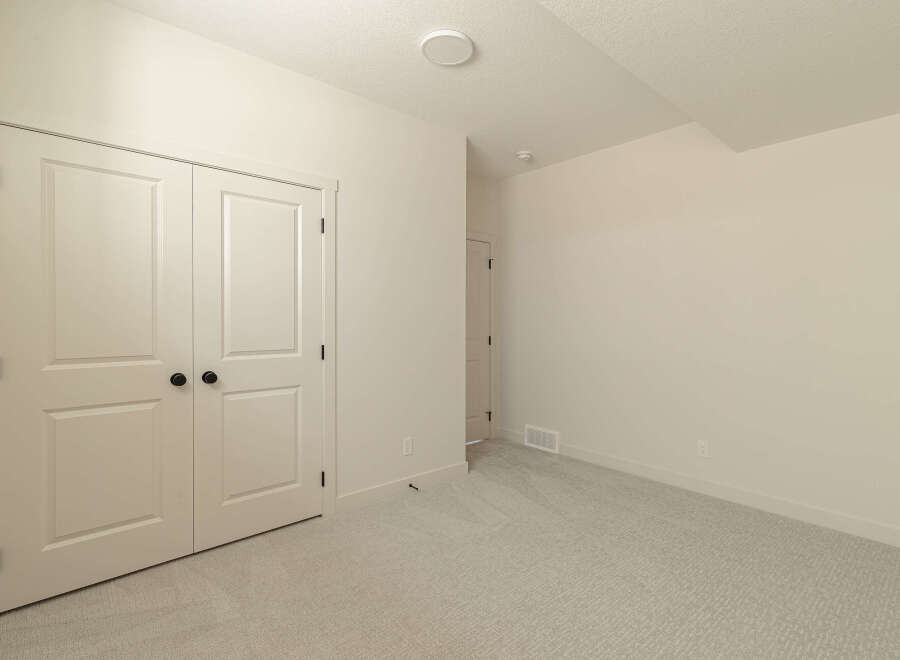 Step into this inviting room, featuring a spacious closet with double doors and elegant black hardware.