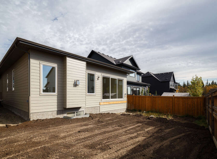 Discover this modern home featuring a light beige siding exterior and large windows that allow for ample natural light.
