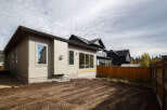 Discover this modern home featuring a light beige siding exterior and large windows that allow for ample natural light.