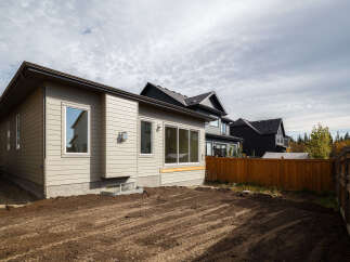 Discover this modern home featuring a light beige siding exterior and large windows that allow for ample natural light.