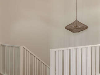 This modern home features a bright and airy staircase with white railings and light wood flooring, creating a seamless flow throughout the space.