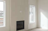 Experience modern living in this bright and airy room featuring a sleek gas fireplace as the focal point.