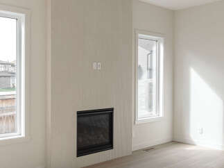 Experience modern living in this bright and airy room featuring a sleek gas fireplace as the focal point.