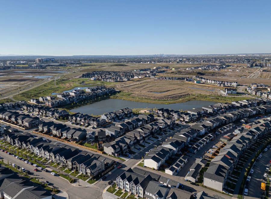 Discover this stunning aerial view of a modern suburban neighborhood, showcasing a collection of contemporary homes with dark roofs and neutral-toned exteriors.