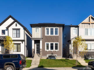 Discover modern living in this stunning townhouse featuring a sleek, contemporary design with a mix of siding and stone accents.