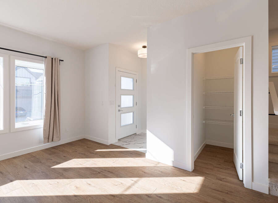 Step into this bright and airy living space, featuring beautiful light wood flooring that catches the sunlight streaming through large windows.