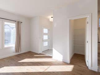 Step into this bright and airy living space, featuring beautiful light wood flooring that catches the sunlight streaming through large windows.