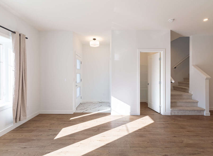 Step into this bright and airy living space, featuring warm wood-look flooring that complements the crisp white walls.