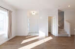 Step into this bright and airy living space, featuring warm wood-look flooring that complements the crisp white walls.