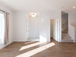 Step into this bright and airy living space, featuring warm wood-look flooring that complements the crisp white walls.