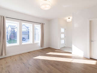 Step into this bright and airy living space, featuring a large bay window that floods the room with natural light.