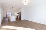 Experience modern living in this stunning open-concept home featuring a sleek white kitchen with stainless steel appliances and a spacious island perfect for entertaining.