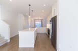 Experience modern living in this stunning kitchen featuring a large white island with ample seating and sleek cabinetry.