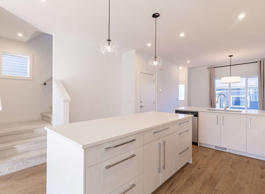 Experience modern living in this stunning kitchen featuring a spacious island with ample counter space and sleek cabinetry.