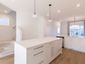 Experience modern living in this stunning kitchen featuring a spacious island with ample counter space and sleek cabinetry.