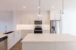 Experience modern living in this stunning kitchen, featuring sleek, light wood cabinetry and a spacious quartz island perfect for entertaining.