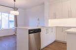 Experience modern living in this stunning kitchen featuring sleek, light wood cabinetry and a spacious island with a built-in dishwasher.