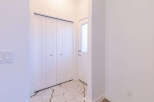 Step into this inviting entryway, featuring a sleek white door with a frosted glass panel, perfect for welcoming guests.