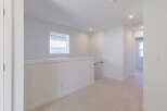 This bright and airy hallway features a modern aesthetic with clean white walls and neutral carpeting.