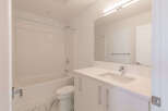 This modern bathroom features a pristine white bathtub and shower combination, complemented by sleek subway tile accents.