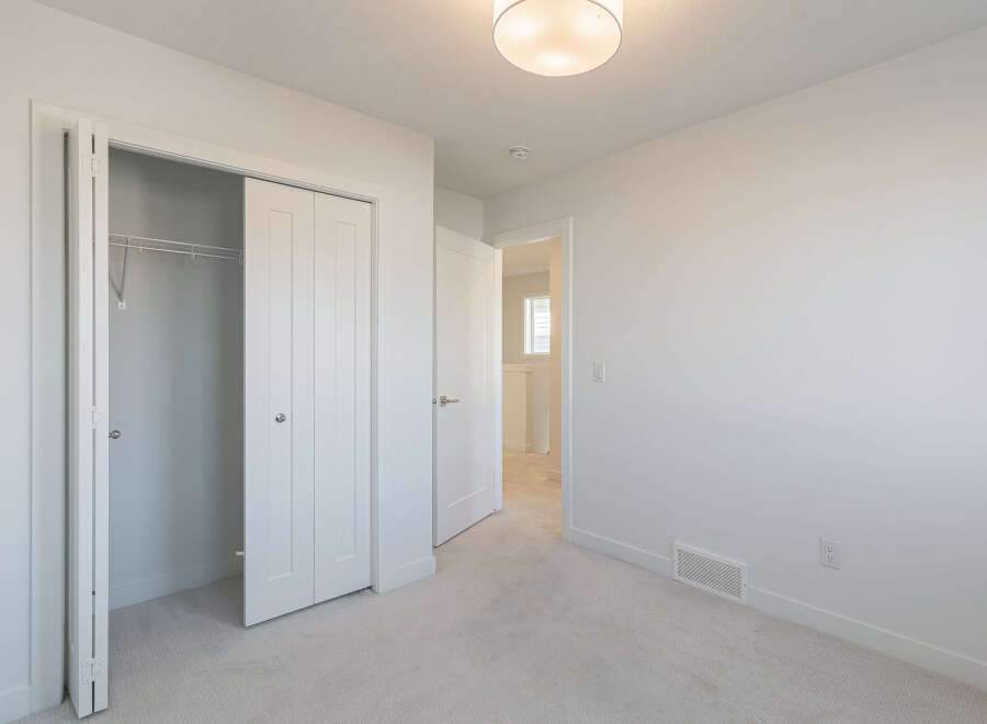Step into this bright and airy bedroom, featuring a spacious closet with sliding doors, perfect for all your storage needs.