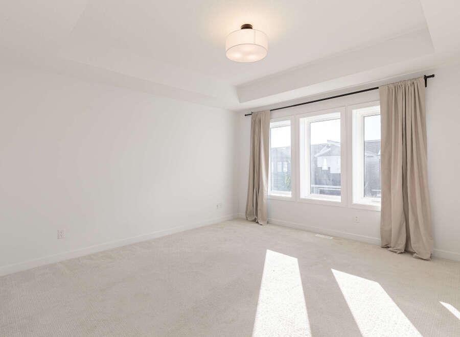 This spacious room features a coffered ceiling with recessed lighting, creating an elegant ambiance.