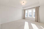 This spacious room features a coffered ceiling with recessed lighting, creating an elegant ambiance.