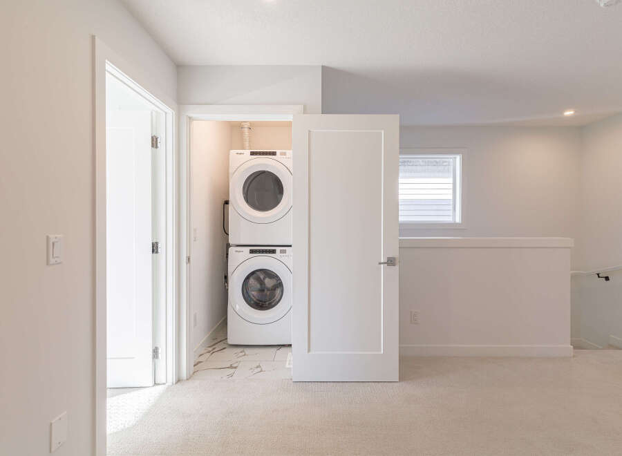Discover the convenience of a stacked Whirlpool washer and dryer, neatly tucked away in a dedicated laundry closet.