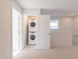 Discover the convenience of a stacked Whirlpool washer and dryer, neatly tucked away in a dedicated laundry closet.