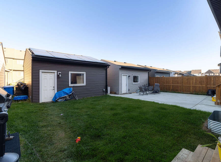 Discover this spacious backyard featuring a well-maintained lawn and a concrete patio, perfect for outdoor entertaining.